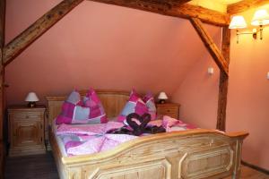 a bedroom with a large bed with pink pillows at Hrazdeny statek Mytinka in Mýtinka