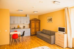 a living room with a couch and a kitchen at Ventspils Rātslaukuma apartamenti in Ventspils