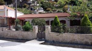 a house with a stone fence and a gate at Artemisia Traditional Home in Choudetsi