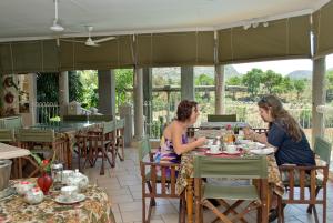 two women sitting at a table in a restaurant at Belvedere-on-River in Malelane