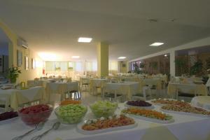 a table with many plates of food on it at Hotel Santa Cruz in Lignano Sabbiadoro