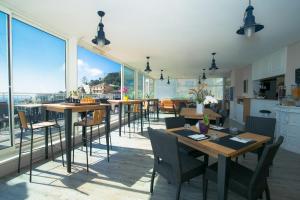 a dining room with tables and chairs and large windows at Hôtel La Fiancée du Pirate in Villefranche-sur-Mer