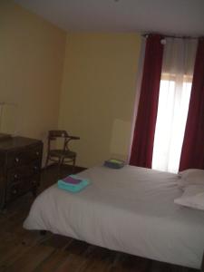 - une chambre avec un lit doté d'un rideau rouge et d'une fenêtre dans l'établissement Chambres d'hôtes du Rebemol, à Le Monastier sur Gazeille