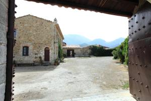 an empty courtyard of a building with mountains in the background at Fattoria Mongerrate in Isnello