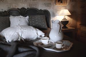 a bed with a tray with two cups and a vase at Masseriola Antiche Fogge in Fasano