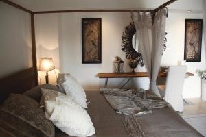 a bedroom with a canopy bed with pillows and a table at Masseriola Antiche Fogge in Fasano