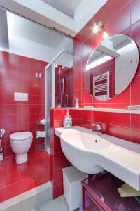 トリノにあるAccogliente mansarda a Porta Nuovaの赤いバスルーム(洗面台、トイレ付)