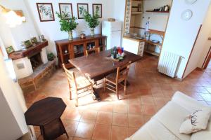a living room with a wooden table and a kitchen at Fattoria Mongerrate in Isnello