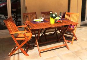 サン・ラファエルにあるL' Aigue Marine terrasse et parkingの木製テーブル(椅子4脚付)、テーブル(ワイングラス付)