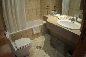 a bathroom with a sink and a toilet and a tub at Uptown Hotel Apartments Abu Dhabi by Gewan in Abu Dhabi