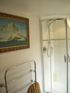 a bathroom with a shower and a painting on the wall at Grayling House in Stoford