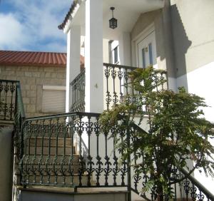a white house with a wrought iron balcony at Casa de Campo Neves in Montalegre