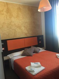 una camera d'albergo con un letto e due asciugamani di Hotel Belvedere Spiaggia a Rimini