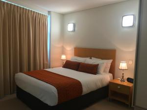 a bedroom with a bed and a lamp at Wallaroo Marina Luxury Apartment in Wallaroo