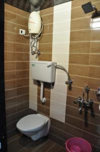 uma casa de banho com WC e um telefone na parede em Hotel Planet Plaza em Mumbai