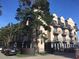 a large building with a tree in front of it at Lazur Wellness@Spa in Międzywodzie