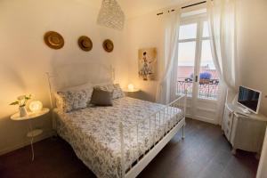 um quarto com uma cama branca e uma janela em Azzurro B&B em Cefalù