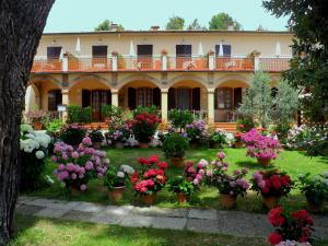 un giardino di fiori di fronte a una casa di Hotel Le Renaie a San Gimignano