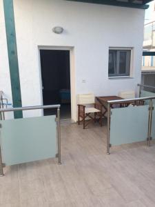 - Balcón con mesa y sillas en un edificio en Socrates Apartmens & Restaurant, en Milatos