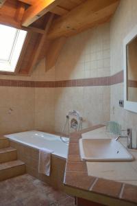 ein großes Bad mit einer Badewanne und einem Waschbecken in der Unterkunft Gästehaus Waldecker in Boos