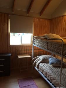 1 dormitorio con litera y ventana en Turismo Montaña Puerto Varas, en Puerto Varas