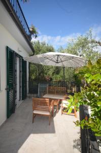 a patio with two benches and an umbrella at Casa Gaia in Lerici