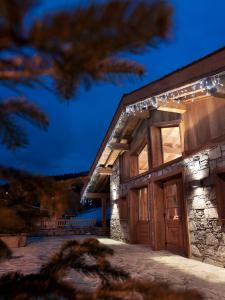 a building with lights on the side of it at CGH Résidences & Spas Les Chalets de Jouvence in Les Carroz d'Araches