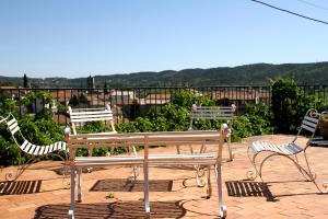 3 chaises et un banc sur une terrasse dans l'établissement Mas de la Filoselle, à Saint-Martin-de-Valgalgues