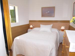 Un dormitorio con una cama blanca y una ventana. en Villa López, en Santanyí 7 fotos más
