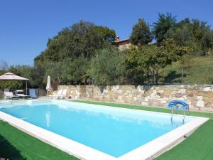 una piscina frente a una pared de piedra en Podere Il Biancospino en Chianciano Terme