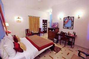 a bedroom with a bed and a desk and a mirror at Hotel Rawalkot Jaisalmer in Jaisalmer