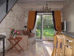 ein Wohnzimmer mit einem Sofa und einem Fenster in der Unterkunft Le four à pain in Varennes