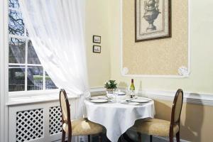 a table with two chairs and a white table cloth at The Circus Apartment in Bath