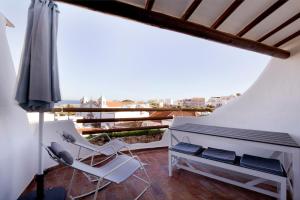 a balcony with a white piano and a chair at The Salty Lodge in Lagos