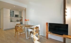 a kitchen and dining room with a table and a tv at The Salty Lodge in Lagos