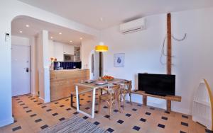 a kitchen and living room with a table and a television at The Salty Lodge in Lagos
