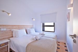 a bedroom with a large white bed with towels on it at The Salty Lodge in Lagos