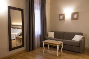 un soggiorno con un divano e uno specchio di Hotel Sesmones a Lodi
