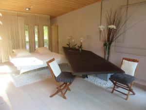 een slaapkamer met een bed en een tafel en stoelen bij D'une Autre Nature in Mesland