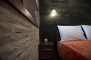 ein Schlafzimmer mit einem Bett und einer Ziegelwand in der Unterkunft Apartments Branko Medjugorje in Međugorje