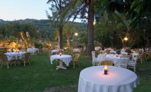 a restaurant with white tables and chairs and palm trees at Hotel Punta Sur in Tarifa