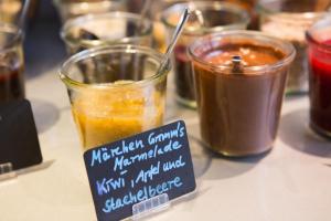 a table topped with jars of different types of food at Grimm's Potsdamer Platz in Berlin