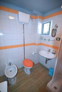 a bathroom with a toilet and a sink at Palazzo Jannoni Holiday in SantʼAndrea Apostolo dello Ionio