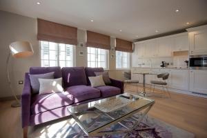 バーミンガムにあるNo.8 Waterloo Streetの紫色のソファ付きのリビングルーム、キッチンが備わります。