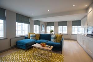 uma sala de estar com um sofá azul e uma mesa em No.8 Waterloo Street em Birmingham