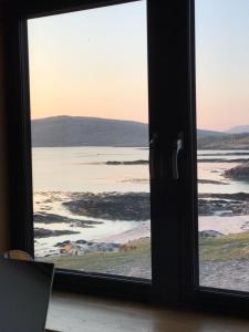 a window with a view of the ocean at An Taigh Mòr in Eriskay +15 photos