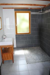 ein Bad mit einem Waschbecken und einem Fenster in der Unterkunft Insolite Bois Cailloux avec Spa in Saint-Remèze