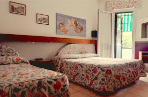 a hotel room with two beds and a window at Hotel Roma in Marghera