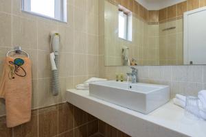 bagno con lavandino bianco e specchio di Gaia Royal a Mastichárion