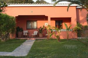 a orange house with a table and chairs in a yard at Hotel Punta Sur in Tarifa